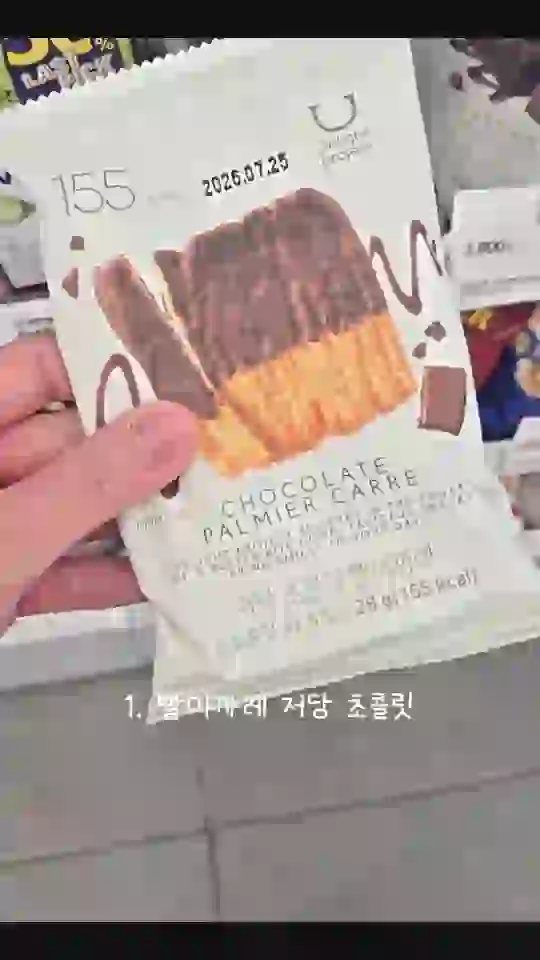 손에 든 초콜릿 과자 봉지 아래에 「1.」 번호가 붙은 상품 이름 자막이 들어간 리뷰 숏폼 장면