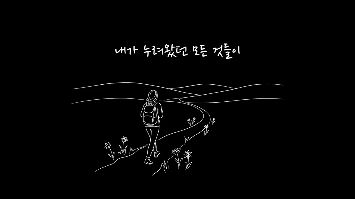 검은 바탕에 흰 선으로 그린, 배낭을 메고 꽃이 핀 굽은 길을 걸어가는 사람 그림 위로 손글씨 가사 자막 한 줄이 뜬 장면